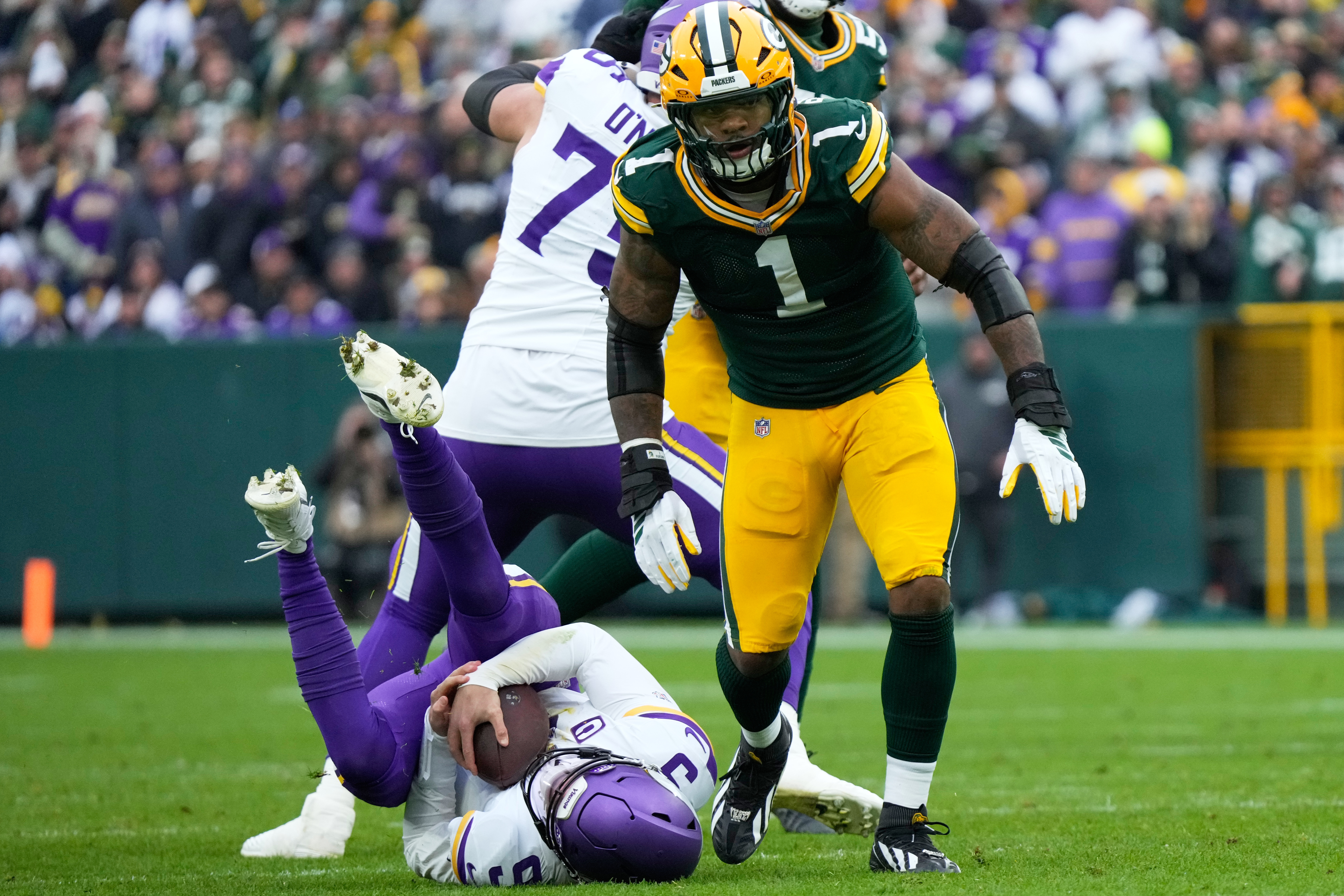 Minnesota Vikings quarterback J.J. McCarthy (9) lays on the ground after being sacked by Green Bay Packers defensive end Micah Parsons (1) during the second half of an NFL football game Sunday, Nov. 23, 2025, in Green Bay, Wis. 