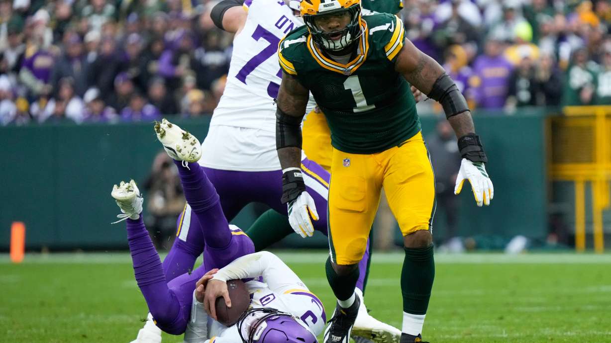 Minnesota Vikings quarterback J.J. McCarthy (9) lays on the ground after being sacked by Green Bay Packers defensive end Micah Parsons (1) during the second half of an NFL football game Sunday, Nov. 23, 2025, in Green Bay, Wis.