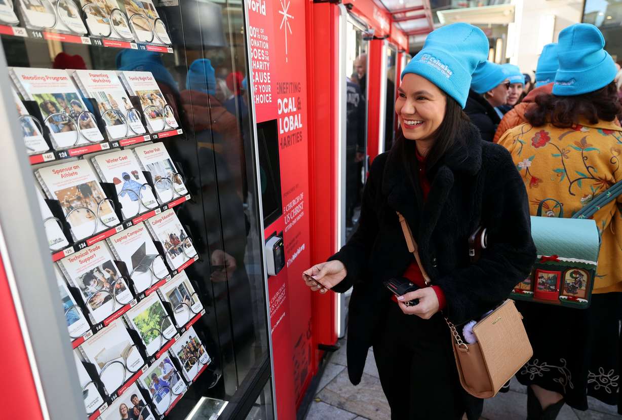 Marilyn Gallardo, who was a student at the Columbus Adult Education Center seven years ago, makes a donation to “sponsor a month of education support for a refugee kid” at the Columbus Adult Education Center during the kickoff celebration for the Light the World Giving Machines at City Creek Center in Salt Lake City on Monday