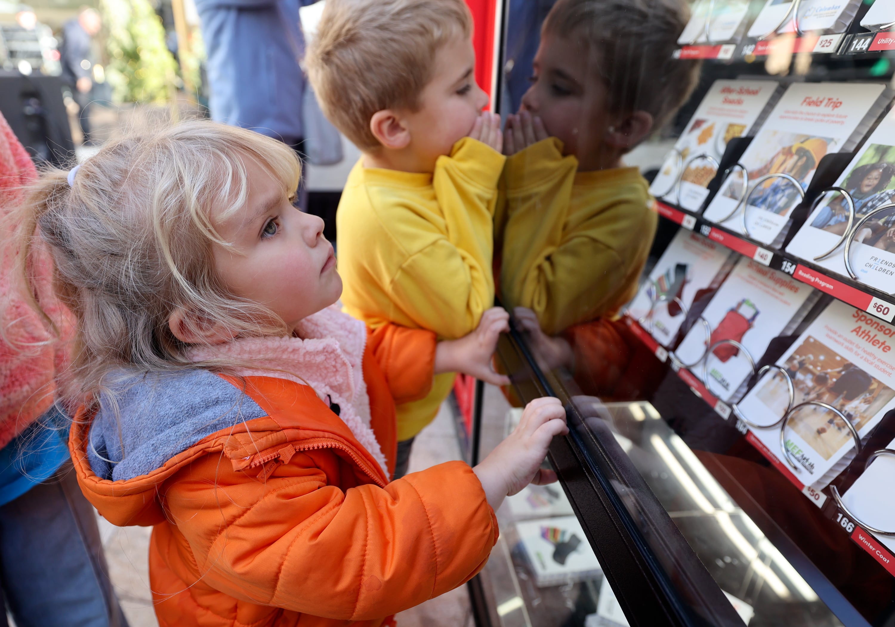 Billie Arthur and Rhett Arthur look at the donation options in a Light the World Giving Machine at City Creek Center in Salt Lake City on Monday.