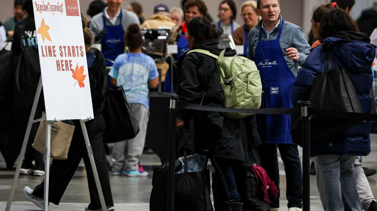 People line up for a meal at the Larry H. Miller Company and Miller Family Season of Service Thanksgiving Meal at the Salt Palace Convention Center in Salt Lake City on Monday.