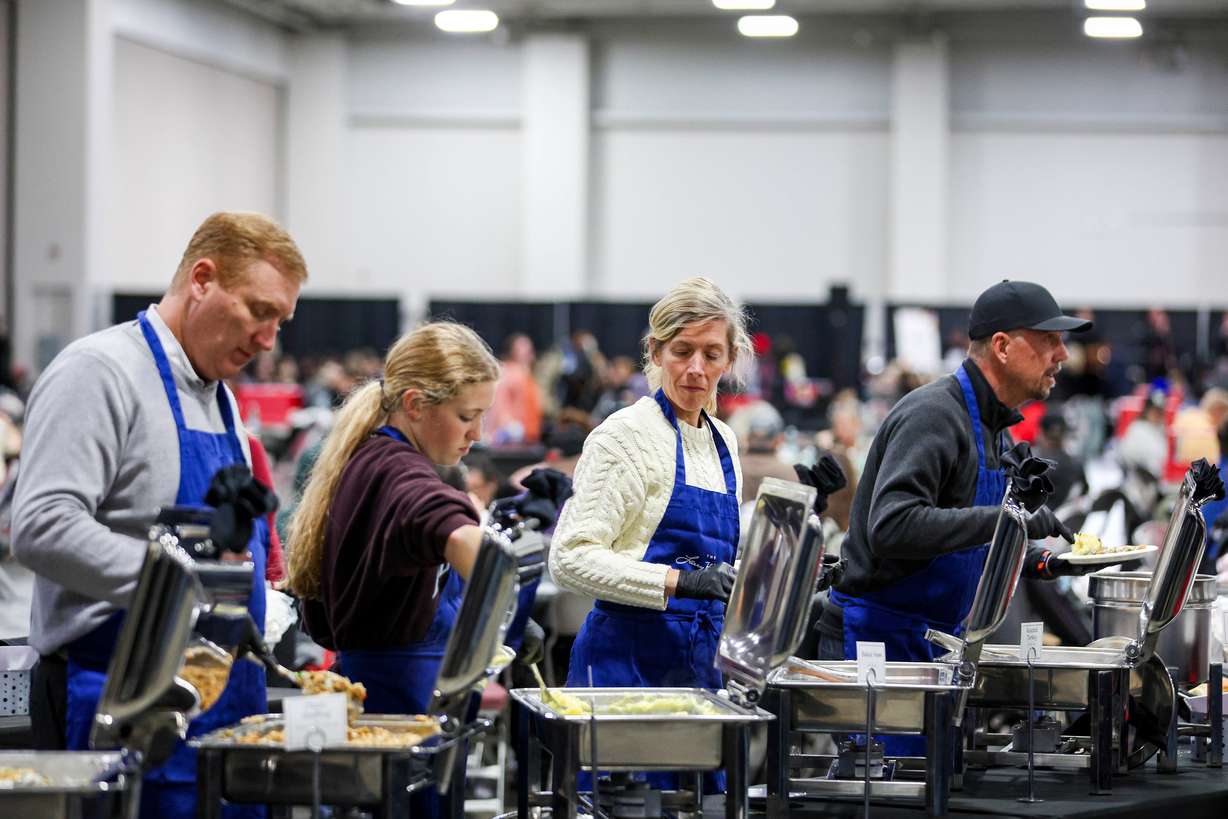 Volunteers help serve food during the Larry H. Miller Company and Miller Family Season of Service Thanksgiving Meal at the Salt Palace Convention Center in Salt Lake City on Monday.