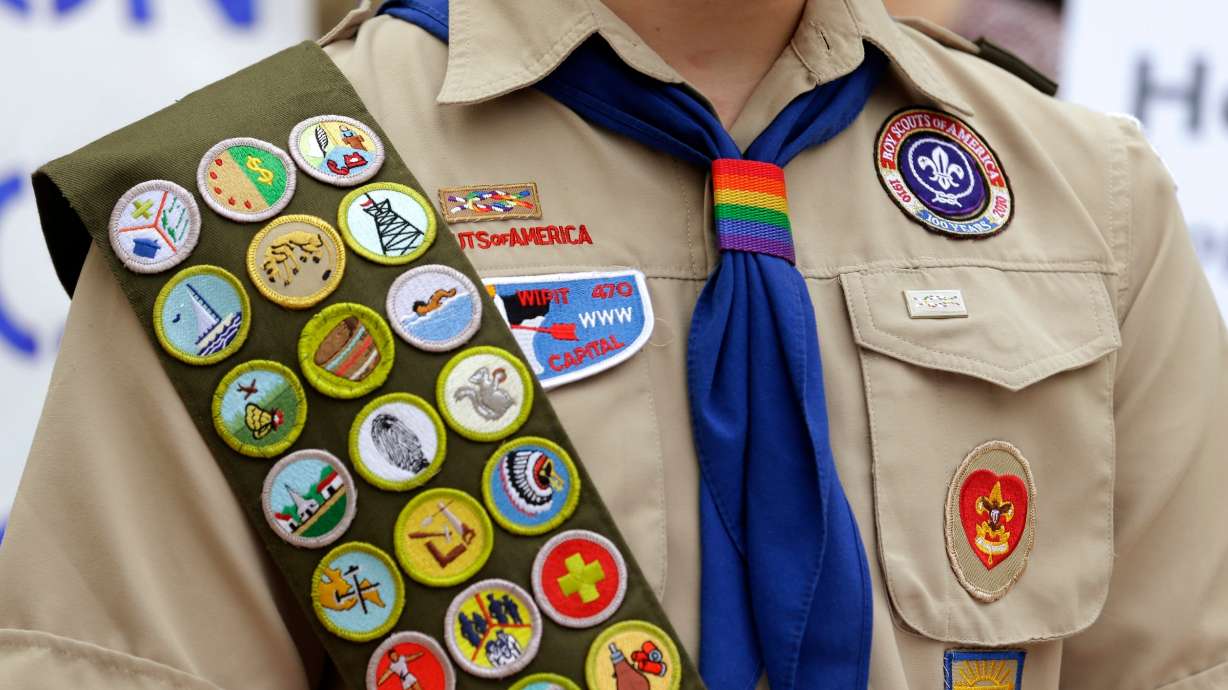 Merit badges and a rainbow-colored neckerchief slider are affixed on a Boy Scout uniform outside the headquarters of Amazon in Seattle. NPR reported Defense Secretary Pete Hegseth said on Tuesday he wants the military to cut ties with Scouting.