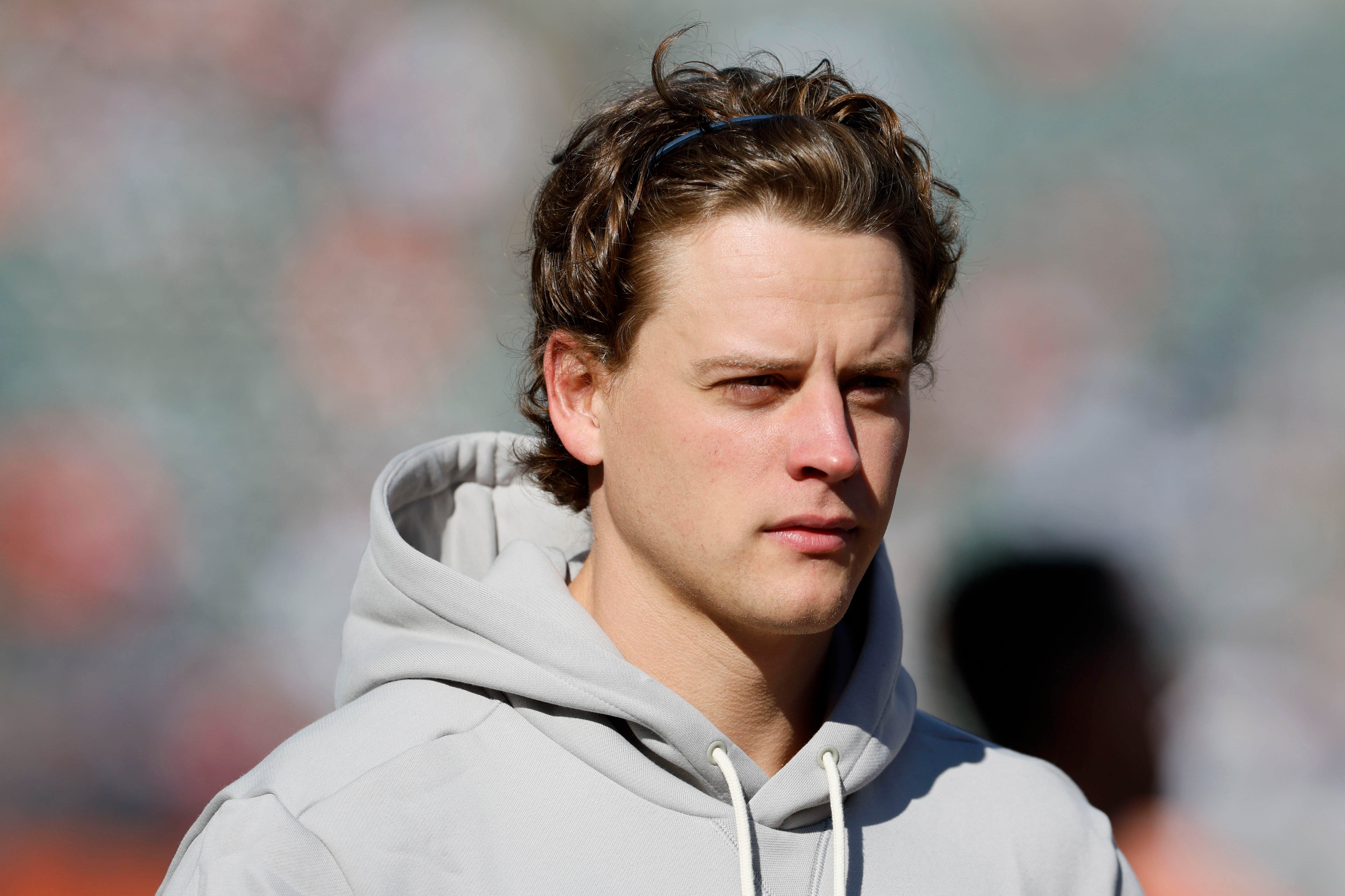 Injured Cincinnati Bengals quarterback Joe Burrow walks on the field before an NFL football game against the New England Patriots, Sunday, Nov. 23, 2025, in Cincinnati. 