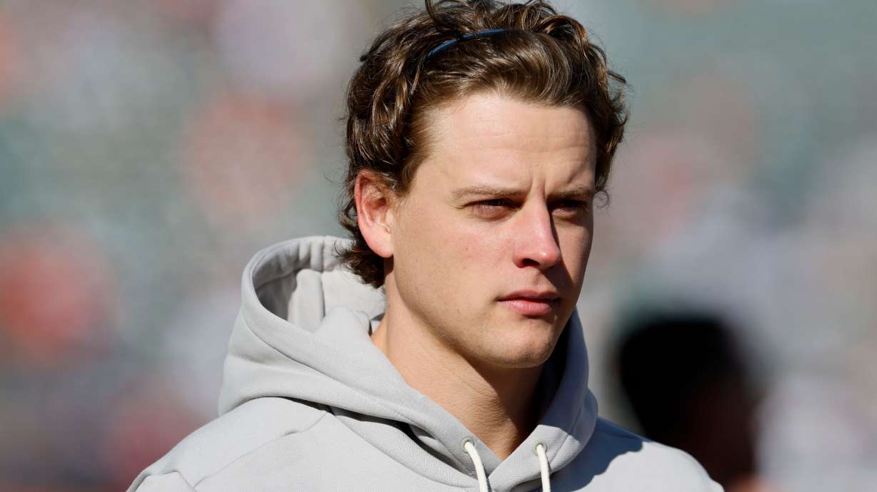 Injured Cincinnati Bengals quarterback Joe Burrow walks on the field before an NFL football game against the New England Patriots, Sunday, Nov. 23, 2025, in Cincinnati.