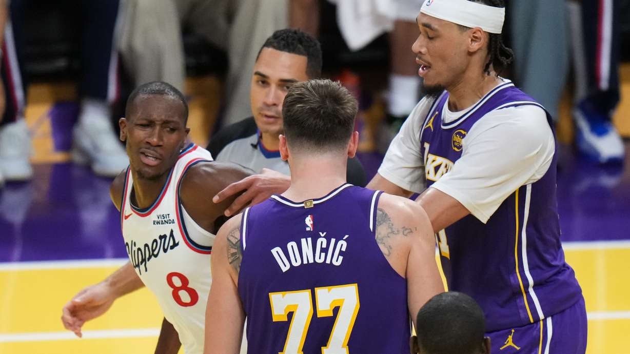 Los Angeles Clippers guard Kris Dunn (8) is pushed by Los Angeles Lakers center Jaxson Hayes (11) after Dunn shoved the ball into Luka Doncic's chest during the second half of an NBA Cup basketball game Tuesday, Nov. 25, 2025, in Los Angeles.