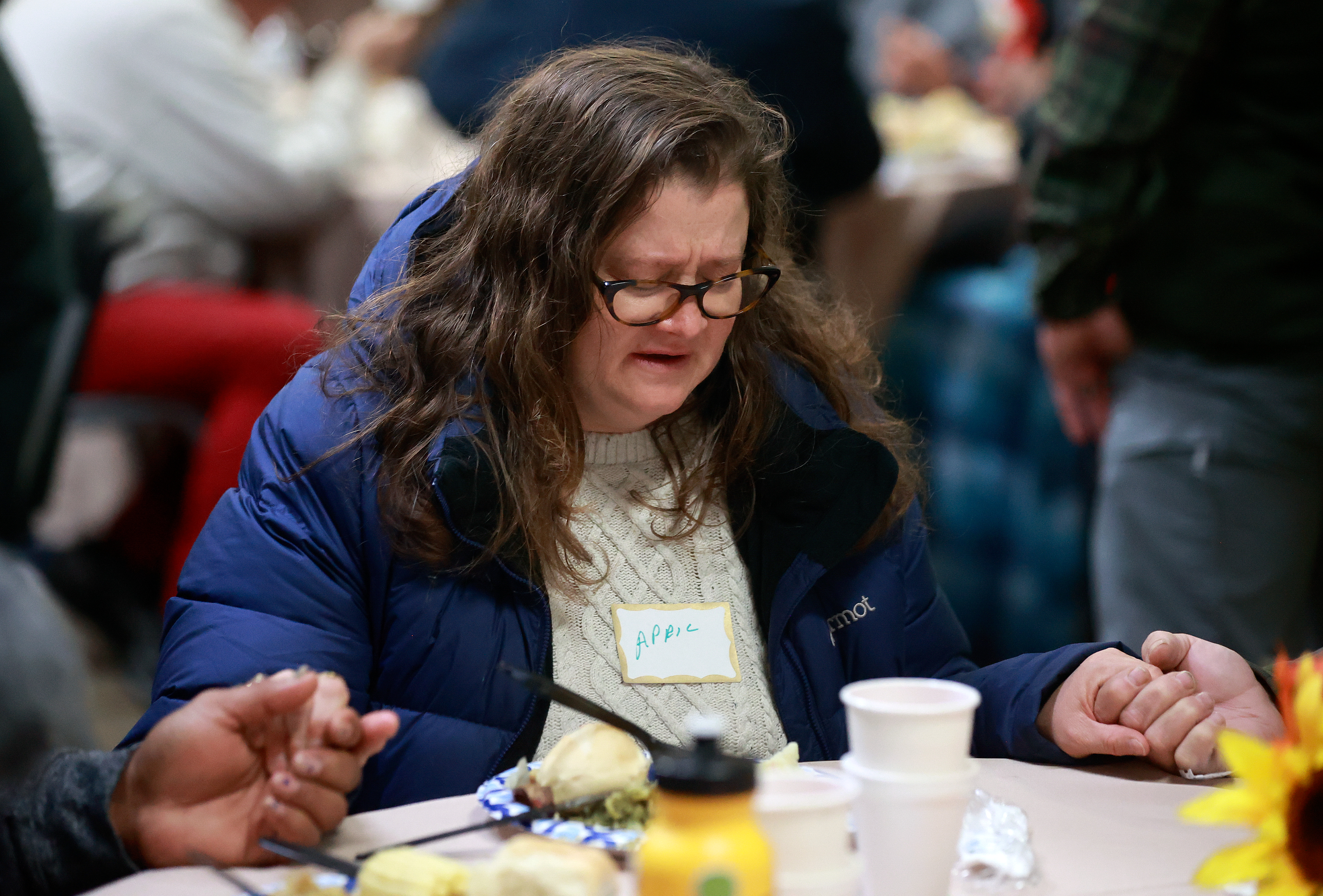April Stevens says a prayer at the annual Thanksgiving banquet at the Rescue Mission in Salt Lake City on Wednesday.
