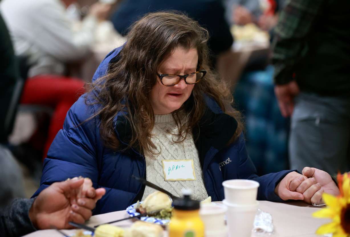 April Stevens says a prayer at the annual Thanksgiving banquet at the Rescue Mission in Salt Lake City on Wednesday.