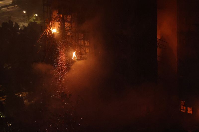 A fire burns bamboo scaffolding on a building at Wang Fuk Court housing estate, in Tai Po, Hong Kong, China, Wednesday. Police said 44 people were dead, with hundreds more still missing.