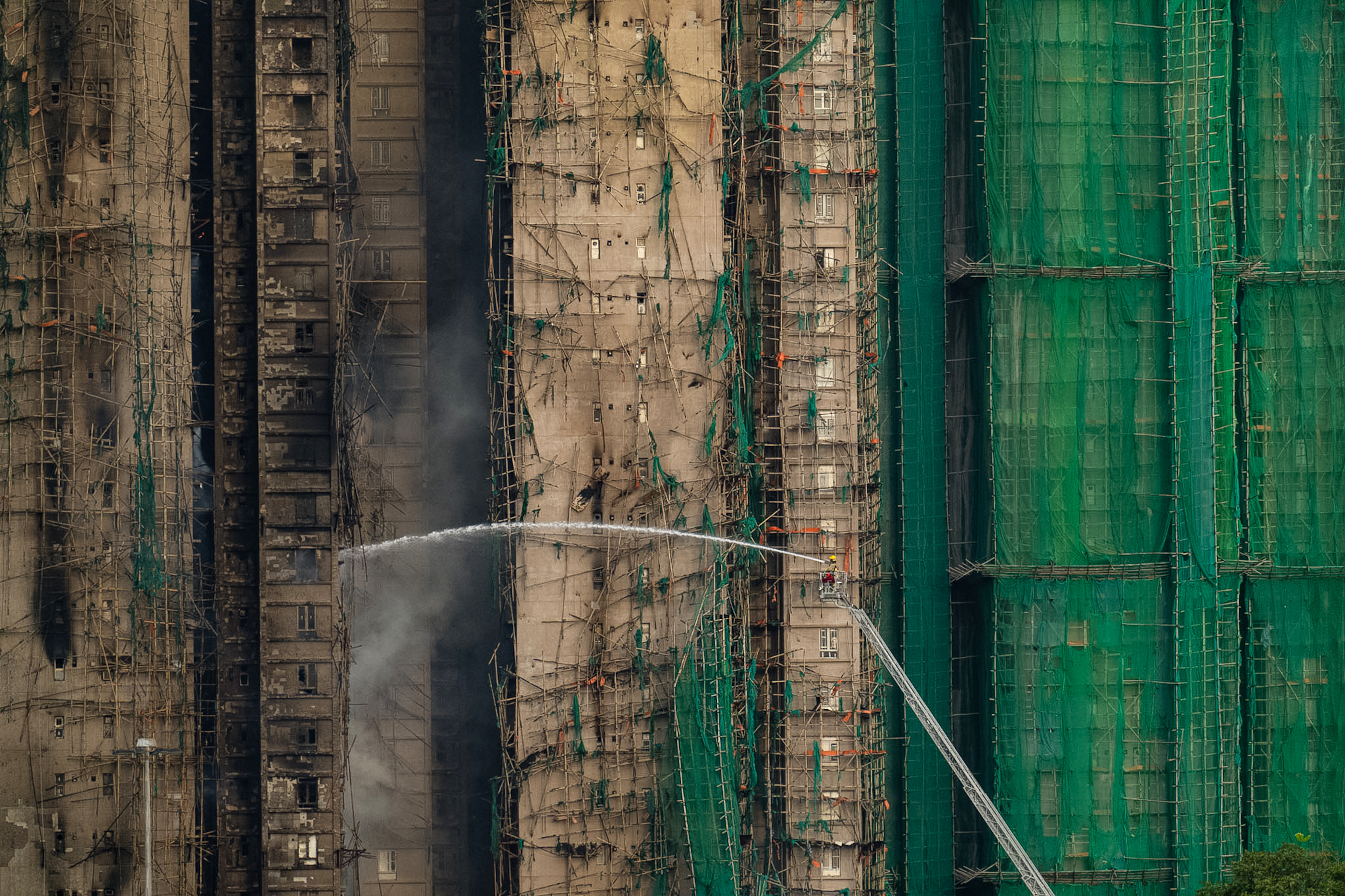 At least 75 dead as Hong Kong firefighters battle burning towers for a second day
