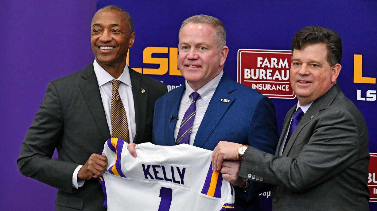 LSU head coach Brian Kelly, center, stands with school president William F. Tate IV, left, and athletic director Scott Woodward, right, as he is introduced during an NCAA college football news conference Dec. 1, 2021, in Baton Rouge, La.