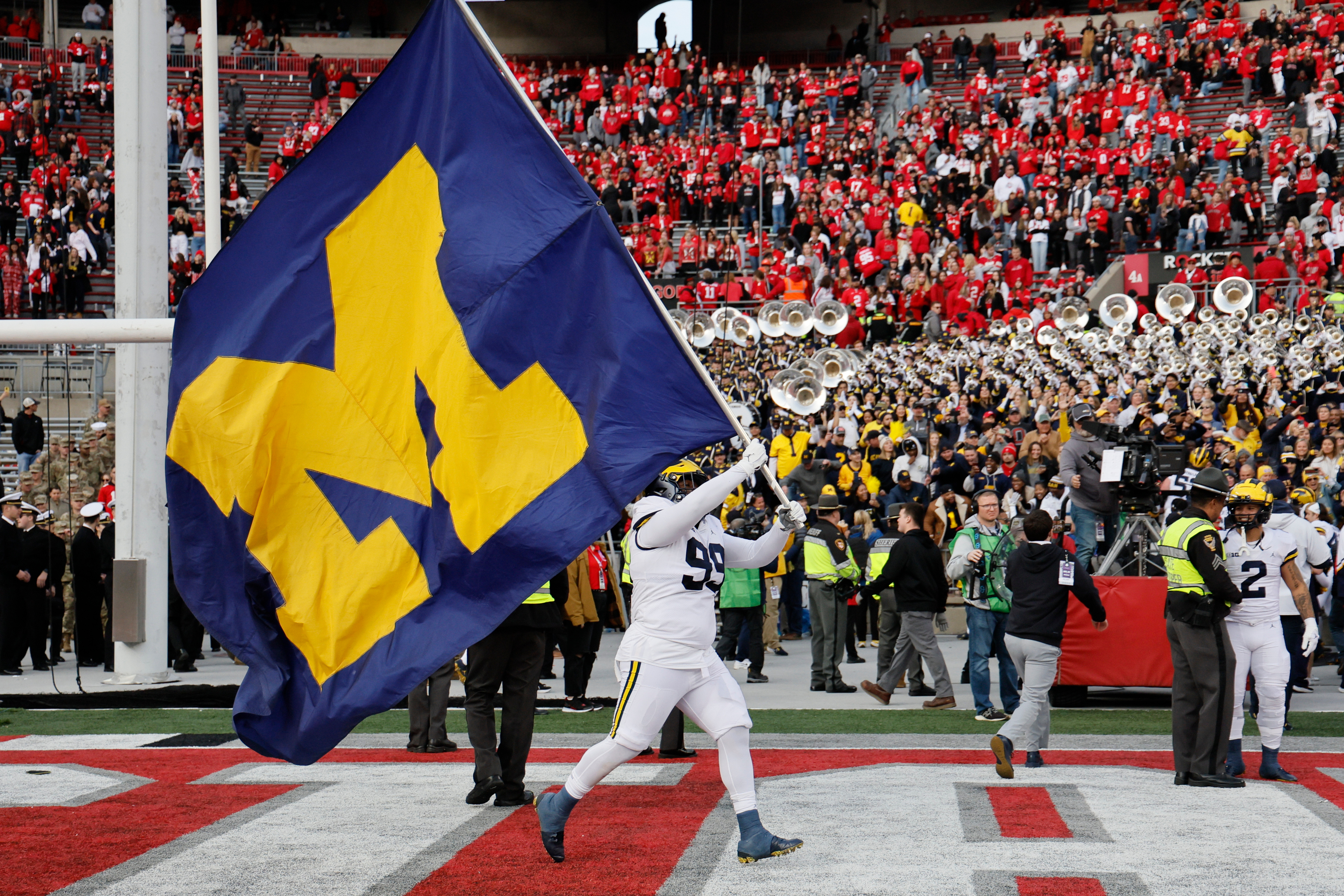 FILE - Michigan defensive lineman Cam Goode waves a Michigan flag after their win over Ohio State in an NCAA college football game ,Nov. 26, 2022, in Columbus, Ohio.