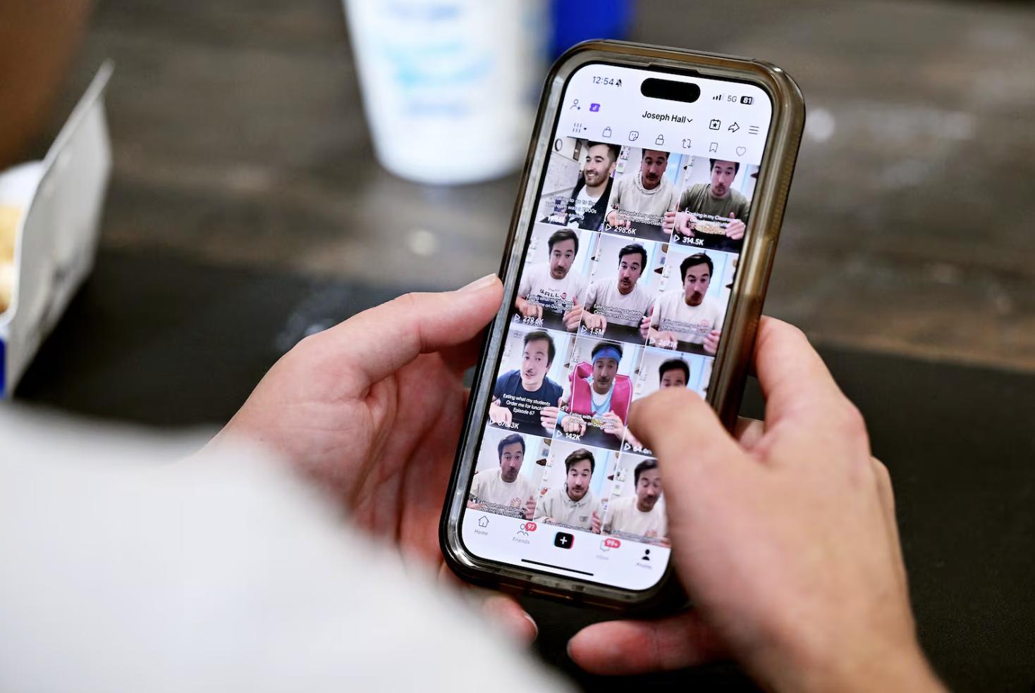 Lehi High School social studies teacher Joey Hall shows some of his videos on his phone after recording a video while on a lunch break at school in Lehi on Nov. 18. Hall has amassed 2.2 million followers on TikTok doing food reviews.