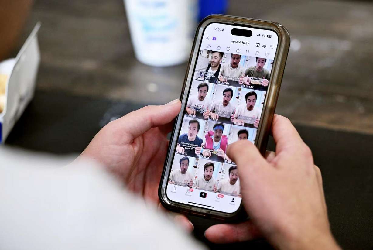 Lehi High School social studies teacher Joey Hall shows some of his videos on his phone after recording a video while on a lunch break at school in Lehi on Nov. 18. Hall has amassed 2.2 million followers on TikTok doing food reviews.