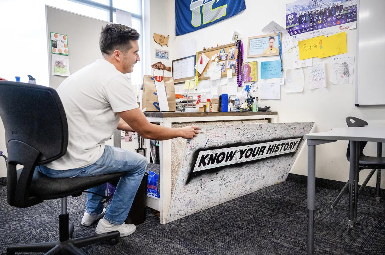 Lehi High School social studies teacher Joey Hall shows a bed that he built into his desk, which he uses when there isn’t time to go home and then back for activities, before recording a video while on his lunch break at school in Lehi on Nov. 18. Hall has amassed 2.2 million followers on TikTok doing food reviews.