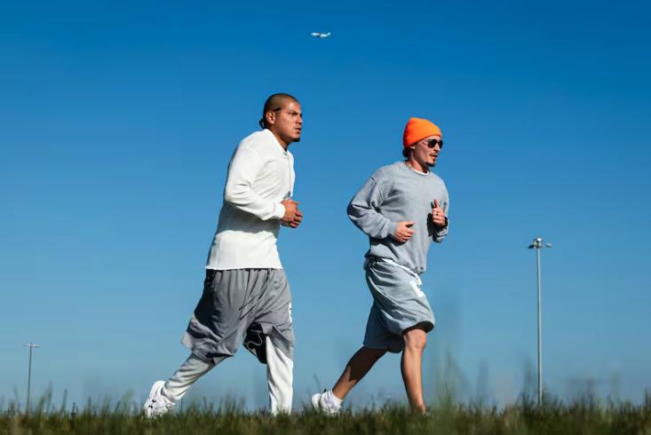 Daniel Garcia, left, and Matthew Mabey run as a plane climbs into the air during the Fit From Within marathon, held at an exercise yard within the Utah State Correctional Facility in Salt Lake City on Nov. 21.