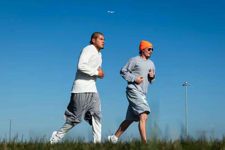Daniel Garcia, left, and Matthew Mabey run as a plane climbs into the air during the Fit From Within marathon, held at an exercise yard within the Utah State Correctional Facility in Salt Lake City on Nov. 21.