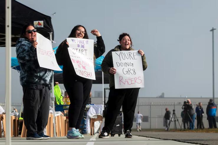 From left, Heather Singleton, Britney Nuñez and Taylor Albrecht, all with Utah’s Division of Correctional Health Services, cheer on incarcerated individuals during the Fit From Within marathon, held at an exercise yard within the Utah State Correctional Facility in Salt Lake City on Nov. 21.