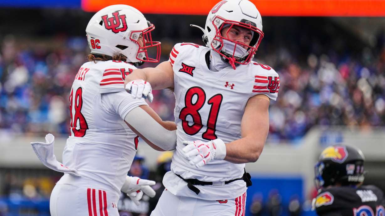 Utah tight ends JJ Buchanan (81) celebrates with tight end Dallen Bentley (88) after Buchanan scored a touchdown during the first half of an NCAA college football game against Kansas, Friday, Nov. 28, 2025, in Lawrence, Kan.