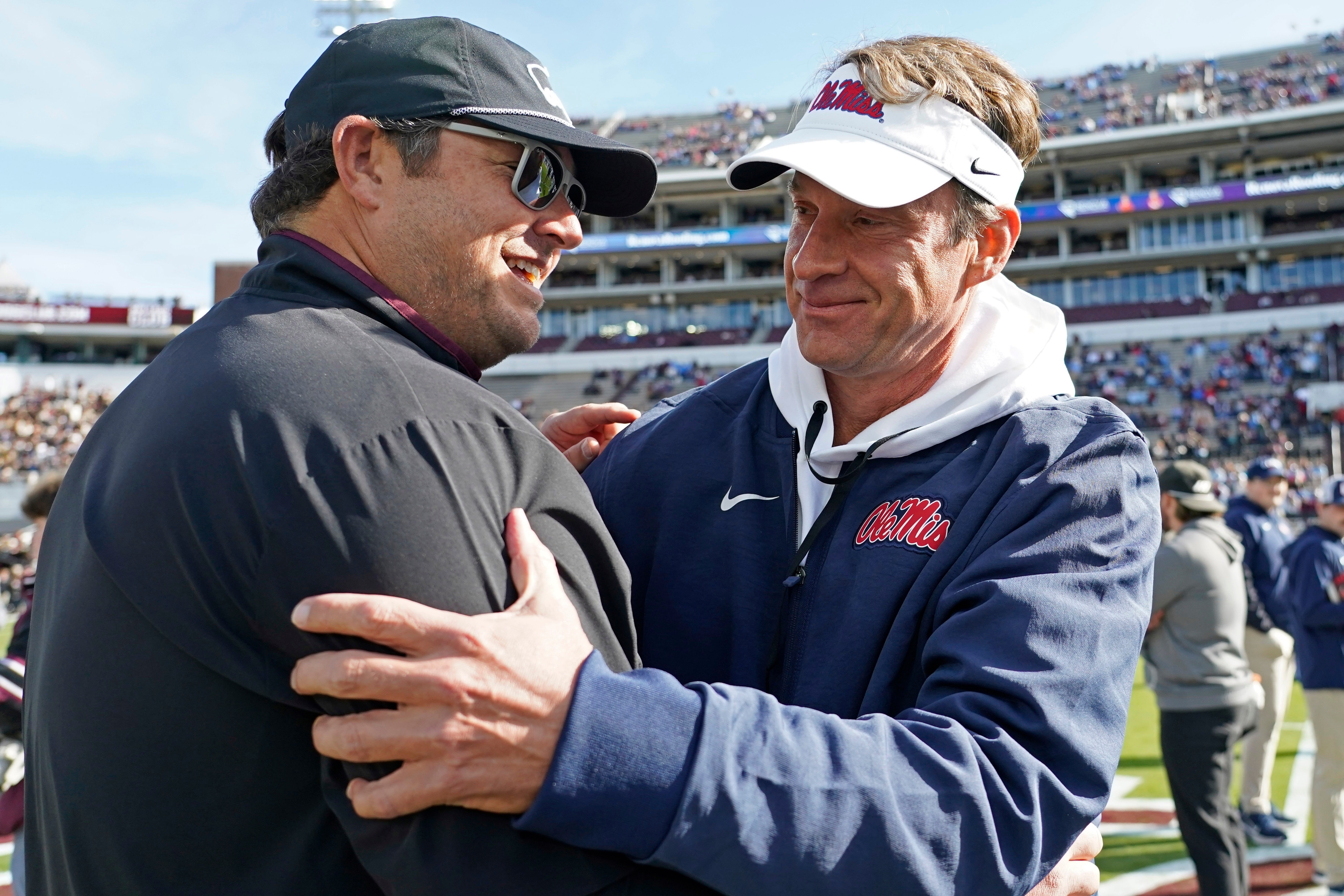 Mississippi head coach Lane Kiffin, right, greets Mississippi State head coach Jeff Lebby prior to their NCAA college football game Friday, Nov. 28, 2025, in Starkville, Miss.