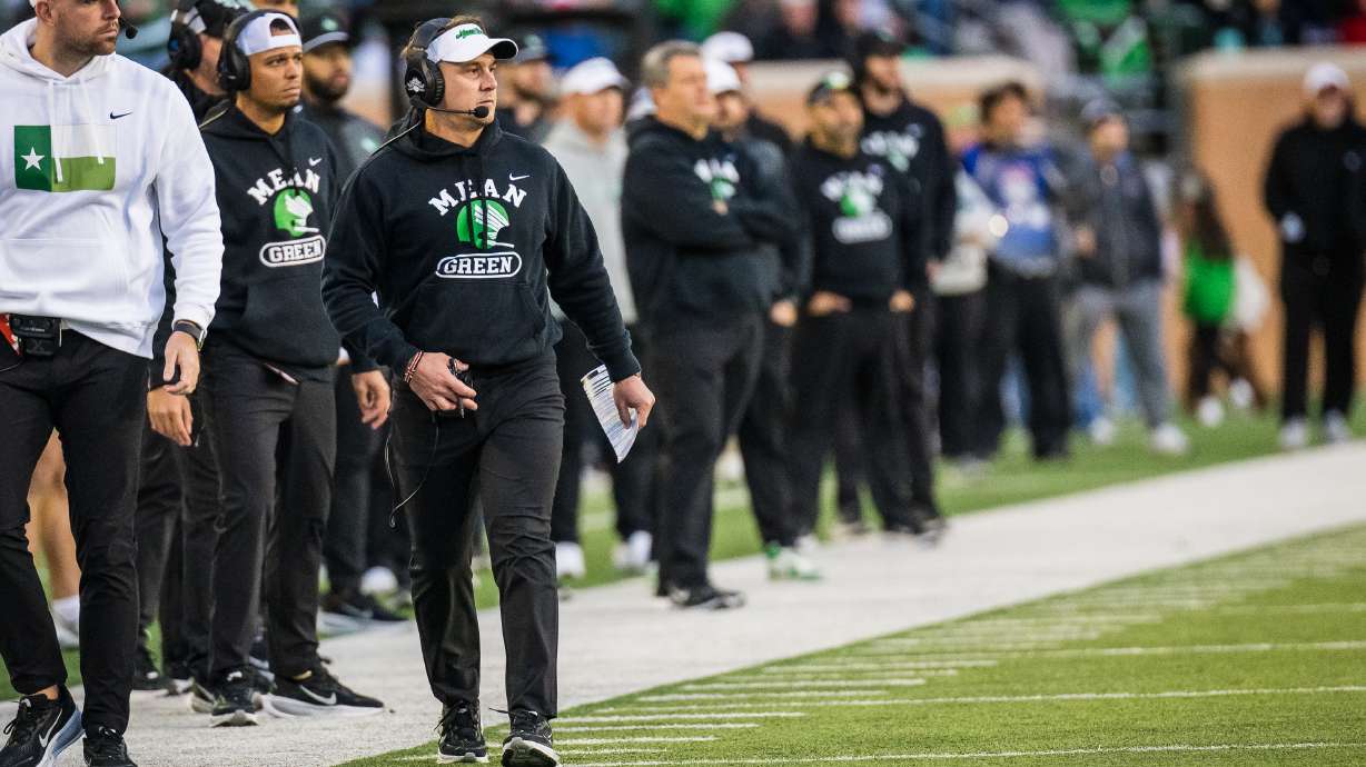 North Texas head coach Eric Morris, front right, walks the sideline during an NCAA college football game against Temple, Friday, Nov. 28, 2025, Denton, Texas.
