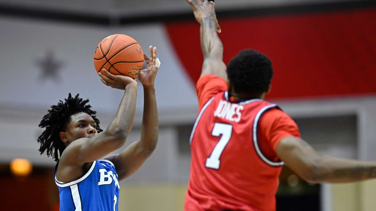 BYU guard Robert Wright III, left, goes up to shoot in front of Dayton forward Keonte Jones (7) during the first half of an NCAA college basketball game, Friday, Nov. 28, 2025, in Kissimmee, Fla.