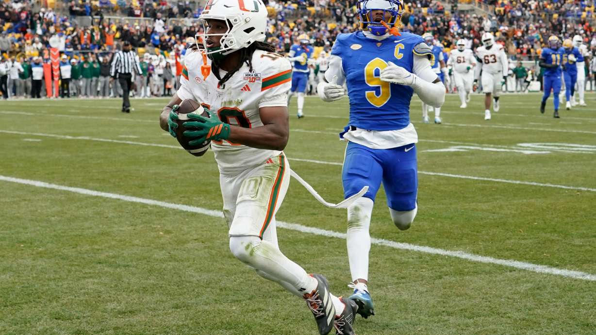 Miami wide receiver Malachi Toney (10) scores in front of Pittsburgh linebacker Kyle Louis (9) during the first half of an NCAA college football game, Saturday, Nov. 29, 2025, in Pittsburgh.