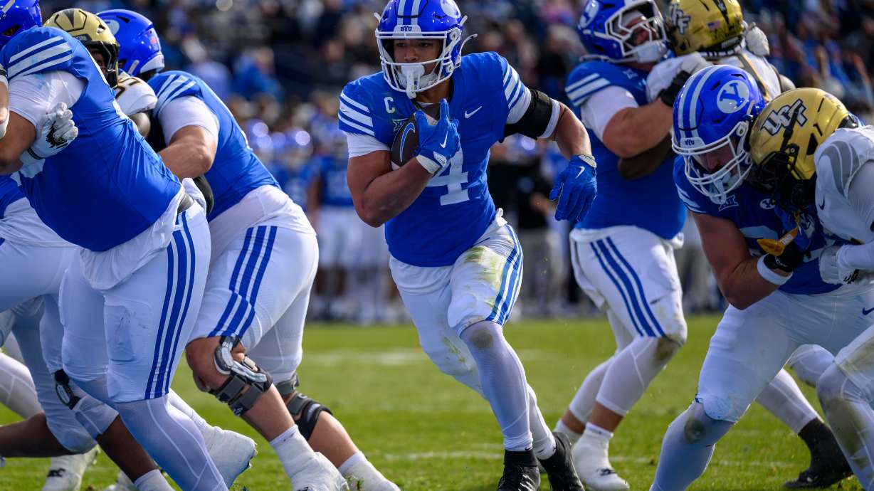 BYU running back LJ Martin (4) runs the ball in for a touchdown during the first half an NCAA college football game, Saturday, Nov. 29, 2025, in Provo, Utah.