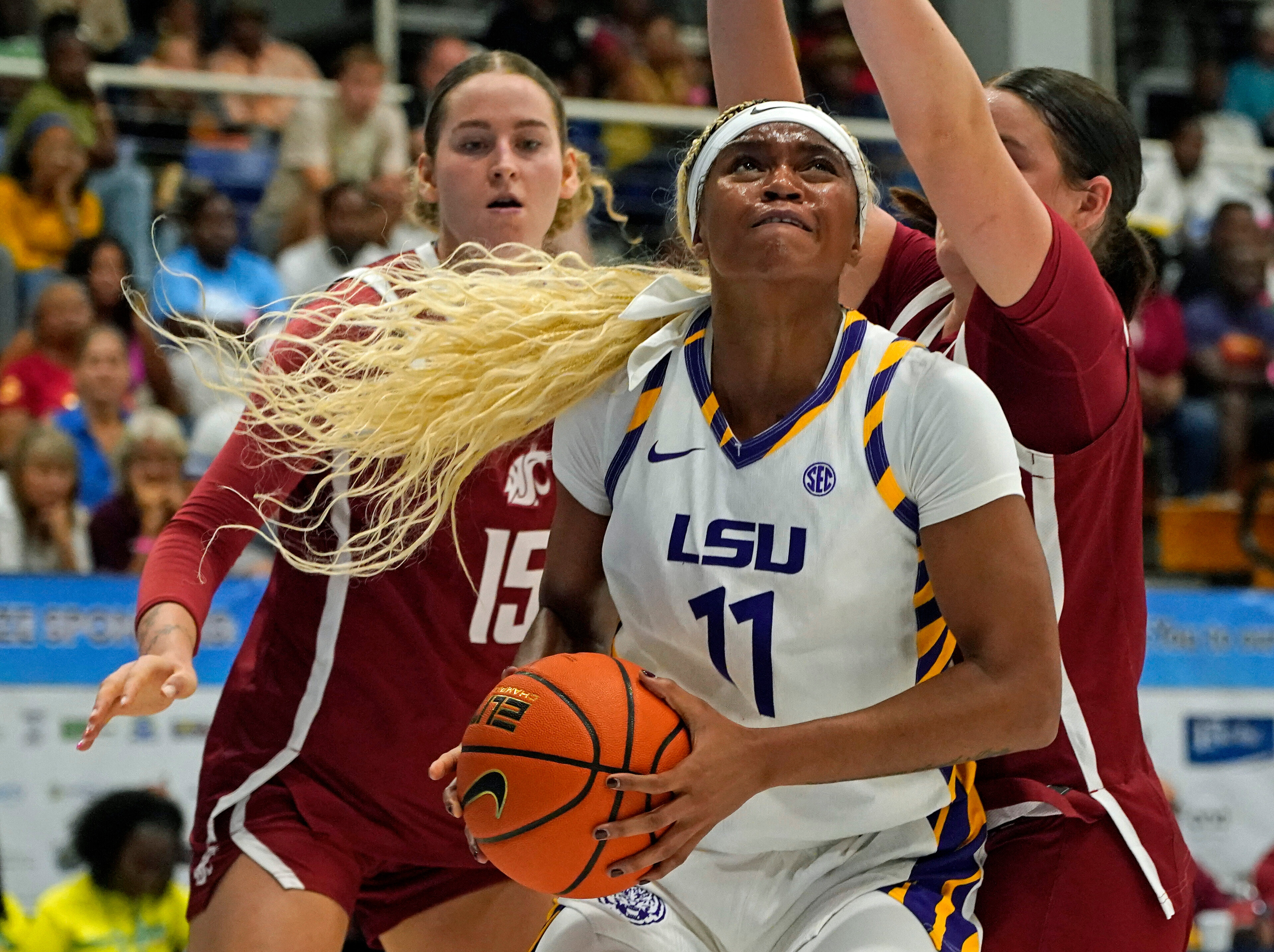 LSU guard ZaKiyah Johnson, center, drives for a shot between Washington State defenders Keandra Koorits, left, and Malia Ruud during the first quarter of their Reef Division championship game at the Paradise Jam NCAA college basketball tournament in St. Thomas, U.S. Virgin Islands, Saturday, Nov. 29, 2025. 