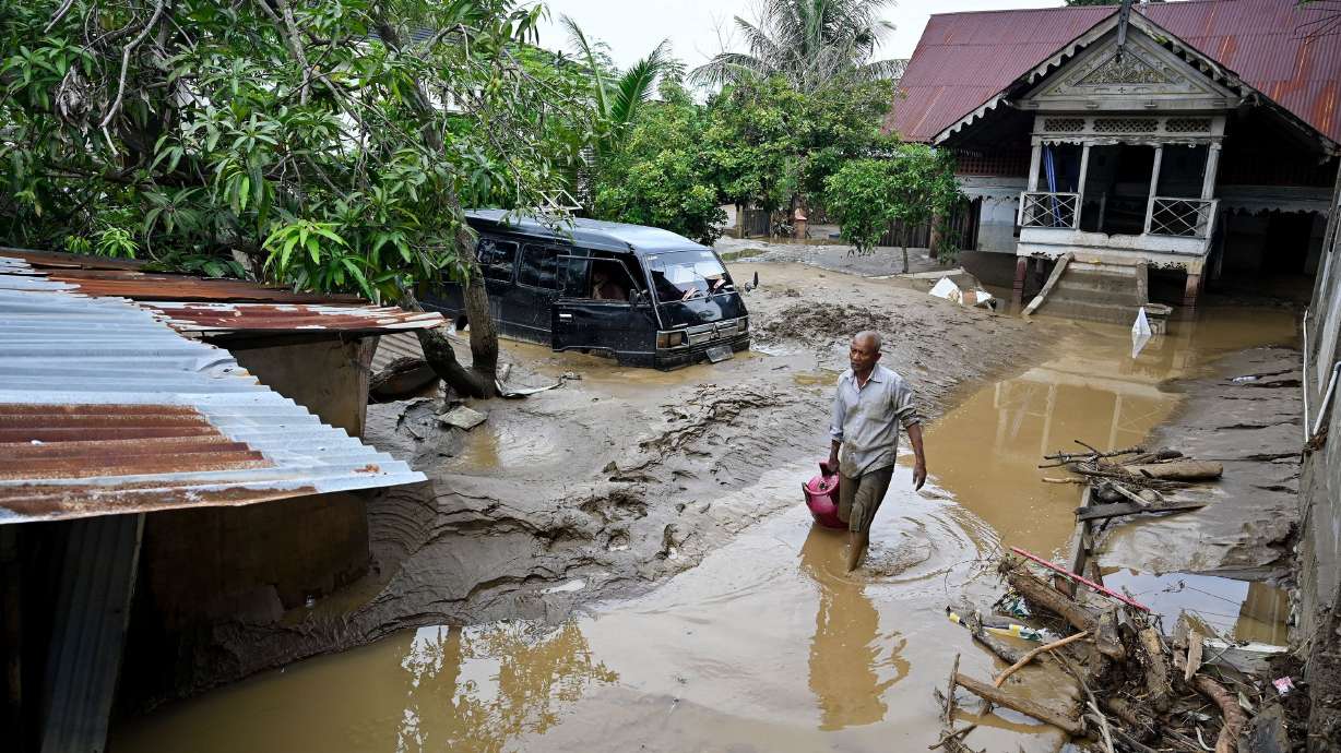 A man wades through the floodwaters following flash floods in Meureudu, in Indonesia's Aceh province, on Friday. Heavy rainfall has unleashed widespread flooding and landslides across Asia, killing more than 900 people with hundreds still missing.