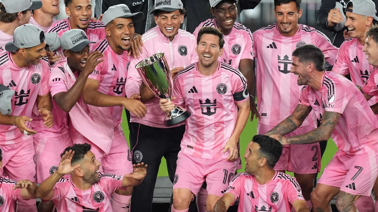 Inter Miami forward Lionel Messi (10) holds the trophy as Inter Miami players celebrate winning an MLS Eastern Conference final soccer match against New York City FC, Saturday, Nov. 29, 2025, in Fort Lauderdale, Fla.