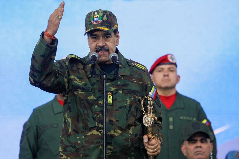 Venezuela's President Nicolas Maduro holds Simon Bolivar's sword as he addresses members of the armed forces, Bolivarian Militia, police, and civilians during a rally against a possible escalation of U.S. actions toward the country, at Fort Tiuna military base in Caracas, Venezuela, Tuesday.