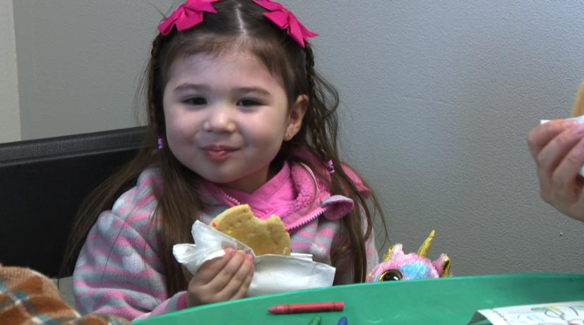 A young girl enjoys a cookie during a party on Sunday in Layton for military families in Utah.