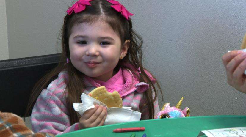 A young girl enjoys a cookie during a party on Sunday in Layton for military families in Utah.