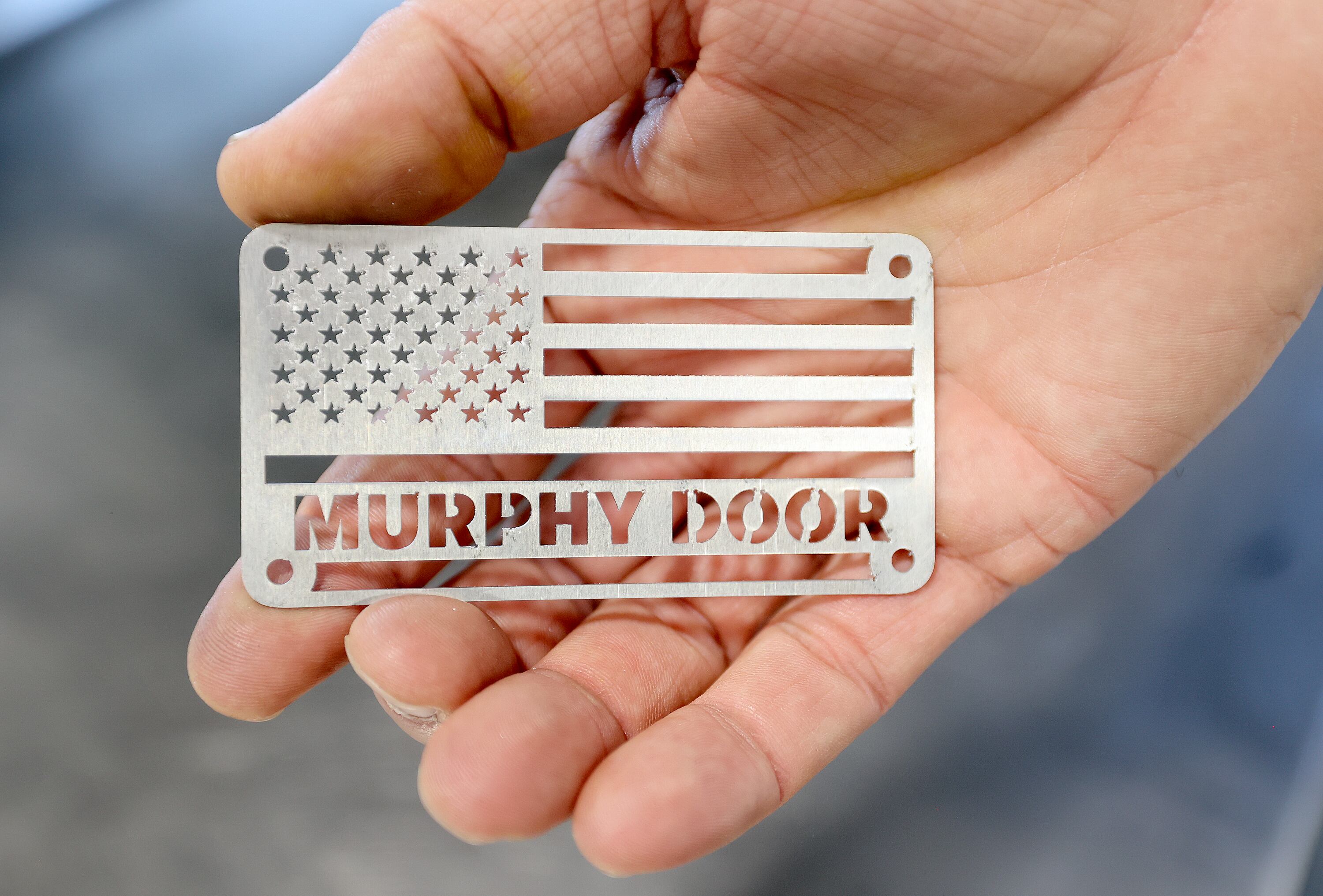 Jeremy Barker, Murphy Door founder and CEO, holds a Murphy Door decal at the Murphy Door factory in West Haven on Oct. 21.