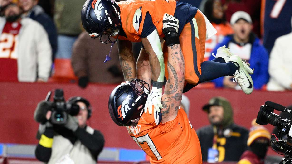 Denver Broncos running back RJ Harvey, is lifted by teammate Quinn Meinerz after scoring during overtime of an NFL football game against the Washington Commanders Sunday, Nov. 30, 2025, in Landover, Md.