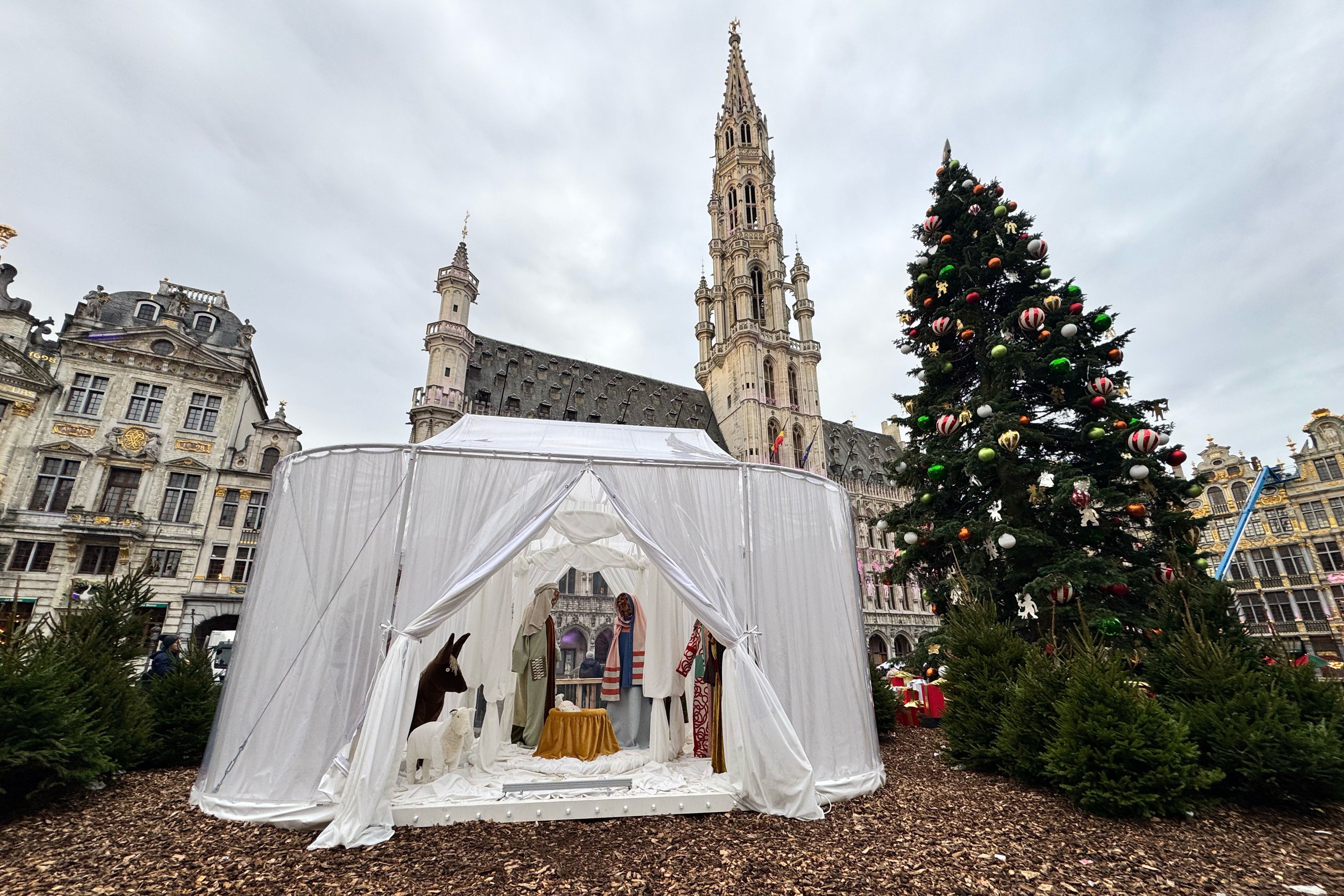 A Nativity scene containing characters with cloth faces, by Belgian artist Victoria-Maria Geyer, is displayed in a white tent in Brussels, Monday.