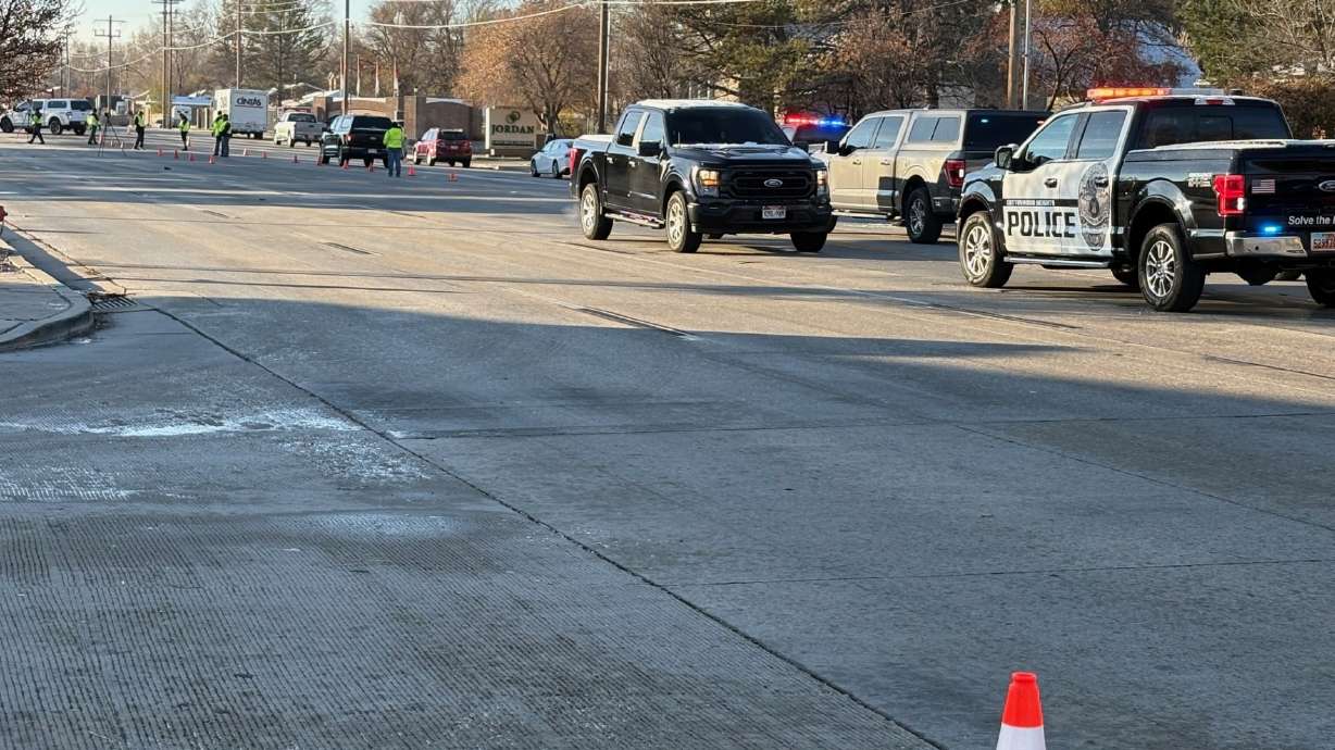 Police respond to the scene of a fatal collision on Redwood Road in West Jordan on Monday.