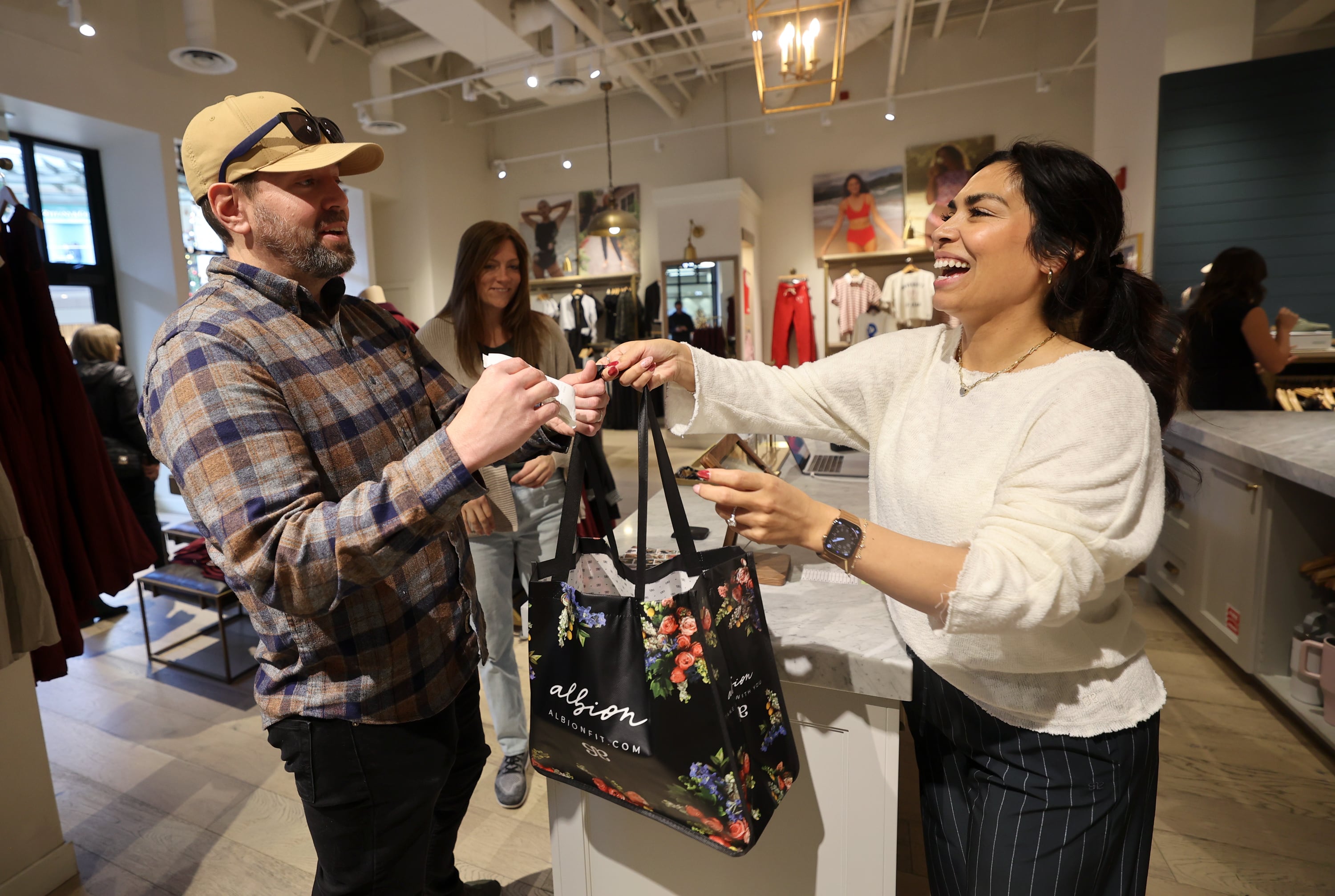 Dan Williams takes his bag from Albion Fit stylist Lorena Rosser while shopping on Black Friday at City Creek Center in Salt Lake City on Friday.