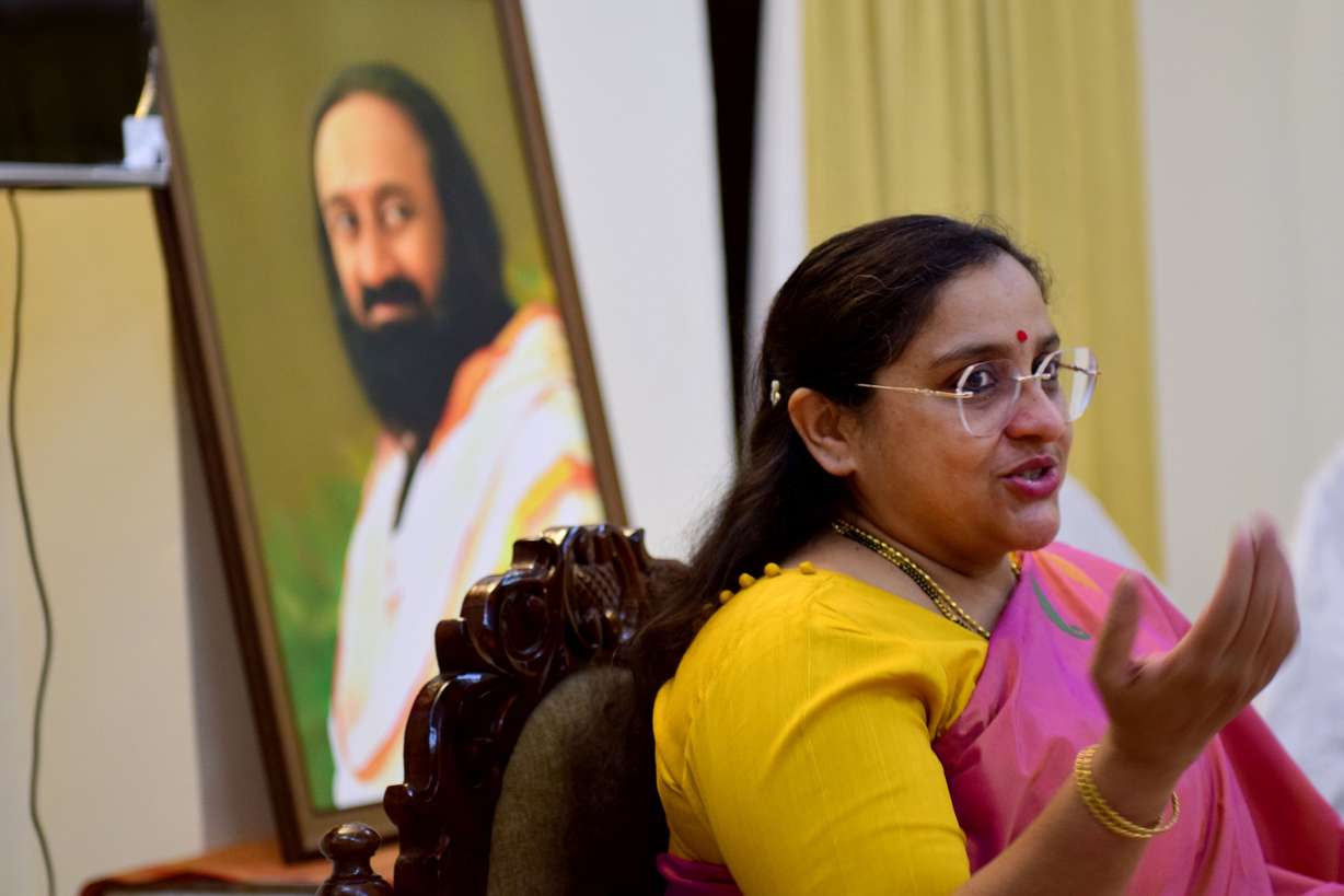 Divya Kanchibhotla leads a meditation for the Utah trade delegation at the Art of Living International Center on Nov. 13. A photo of Sri Sri Ravi Shankar, a spiritual leader behind the organization, sits behind her.
