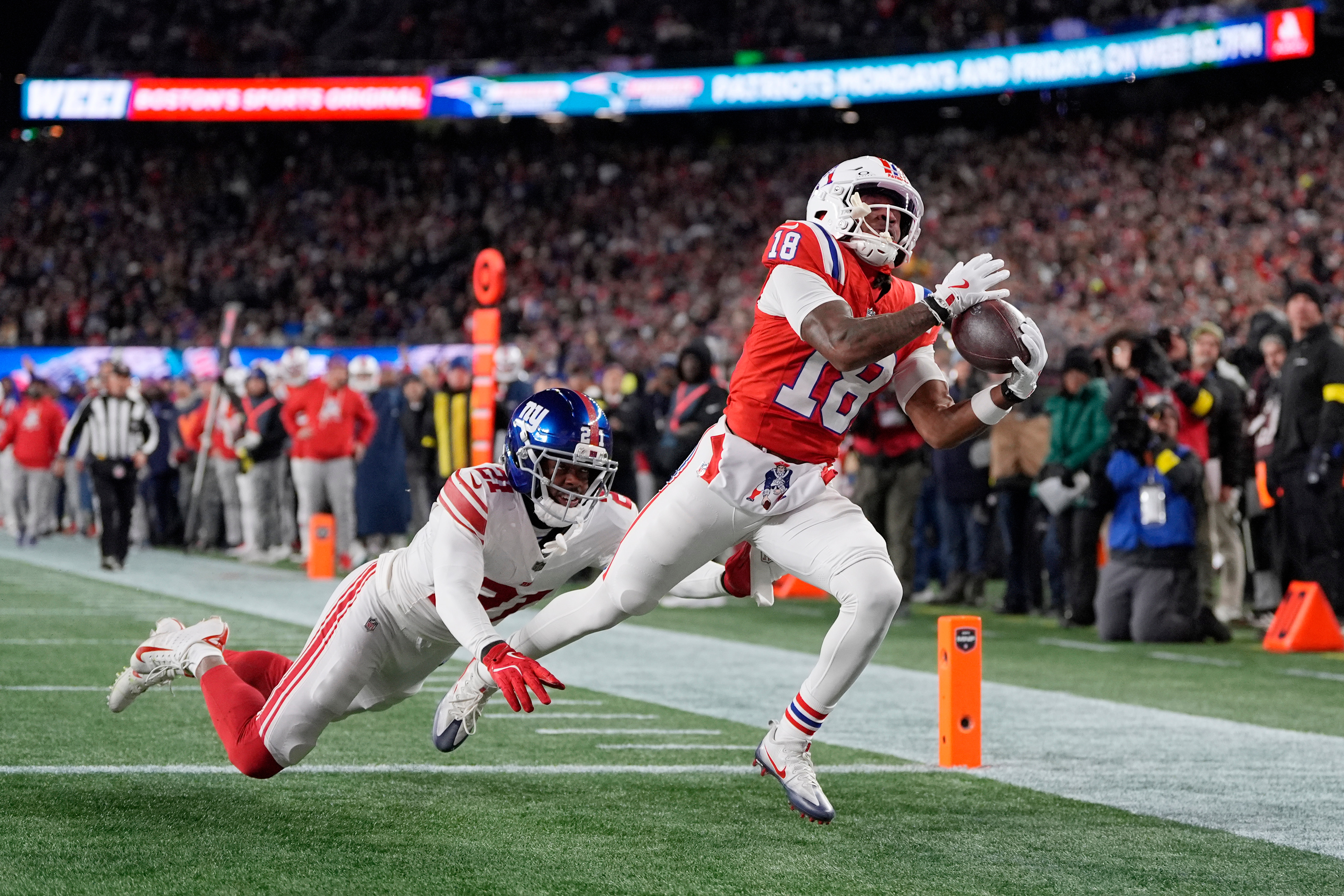 New England Patriots wide receiver Kyle Williams (18) catches a touchdown pass against New York Giants cornerback Paulson Adebo (21) during the first half of an NFL football game Monday, Dec. 1, 2025, in Foxborough, Mass.