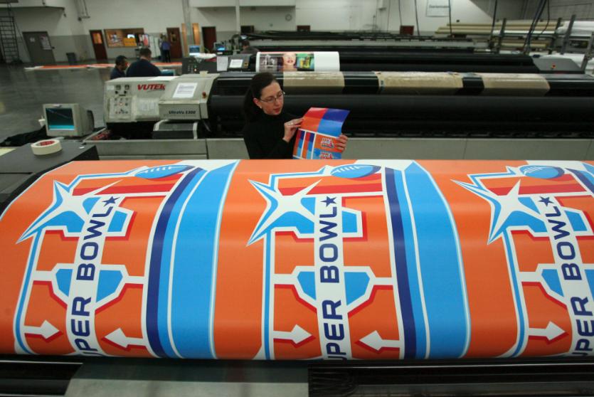 Molly Mazzolini (Infinite Scale Design Group) looks over a color palette for the Super Bowl XLI wrap. The 225-foot High, 70-foot wide vinyl mesh Endzone Pylon Building Wrap covered the NFL Headquarters in Miami at the Marriott, Jan. 4, 2006.