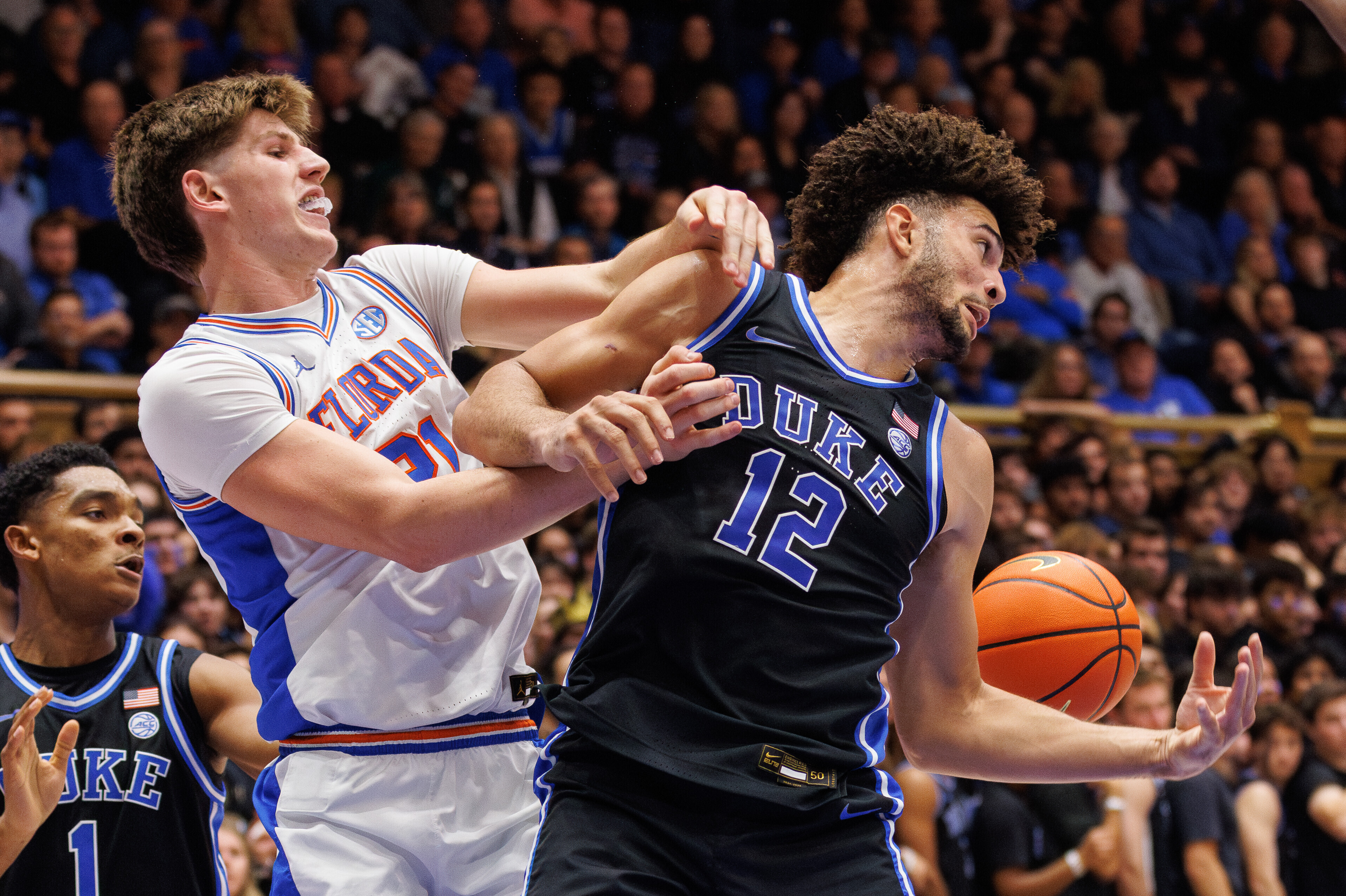 Duke's Cameron Boozer (12) and Floida's Alex Condon (21) battle for a loose ball during the first half of an NCAA college basketball game in Durham, N.C., Tuesday, Dec. 2, 2025. 