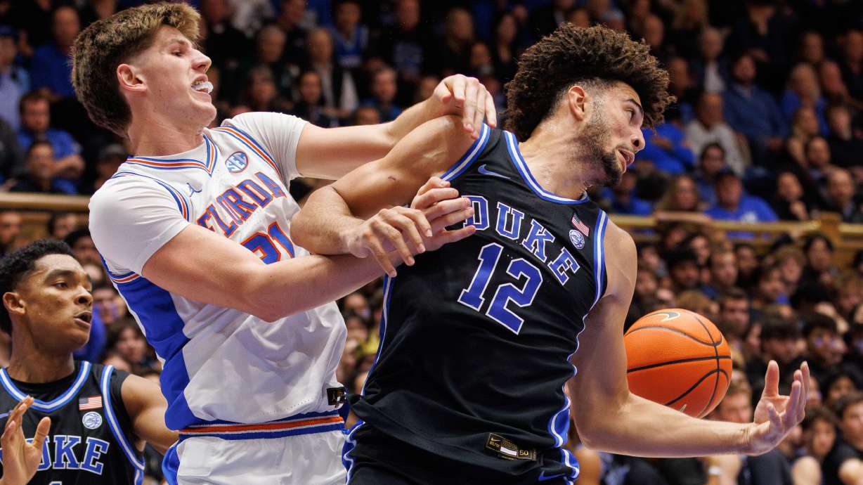 Duke's Cameron Boozer (12) and Floida's Alex Condon (21) battle for a loose ball during the first half of an NCAA college basketball game in Durham, N.C., Tuesday, Dec. 2, 2025.
