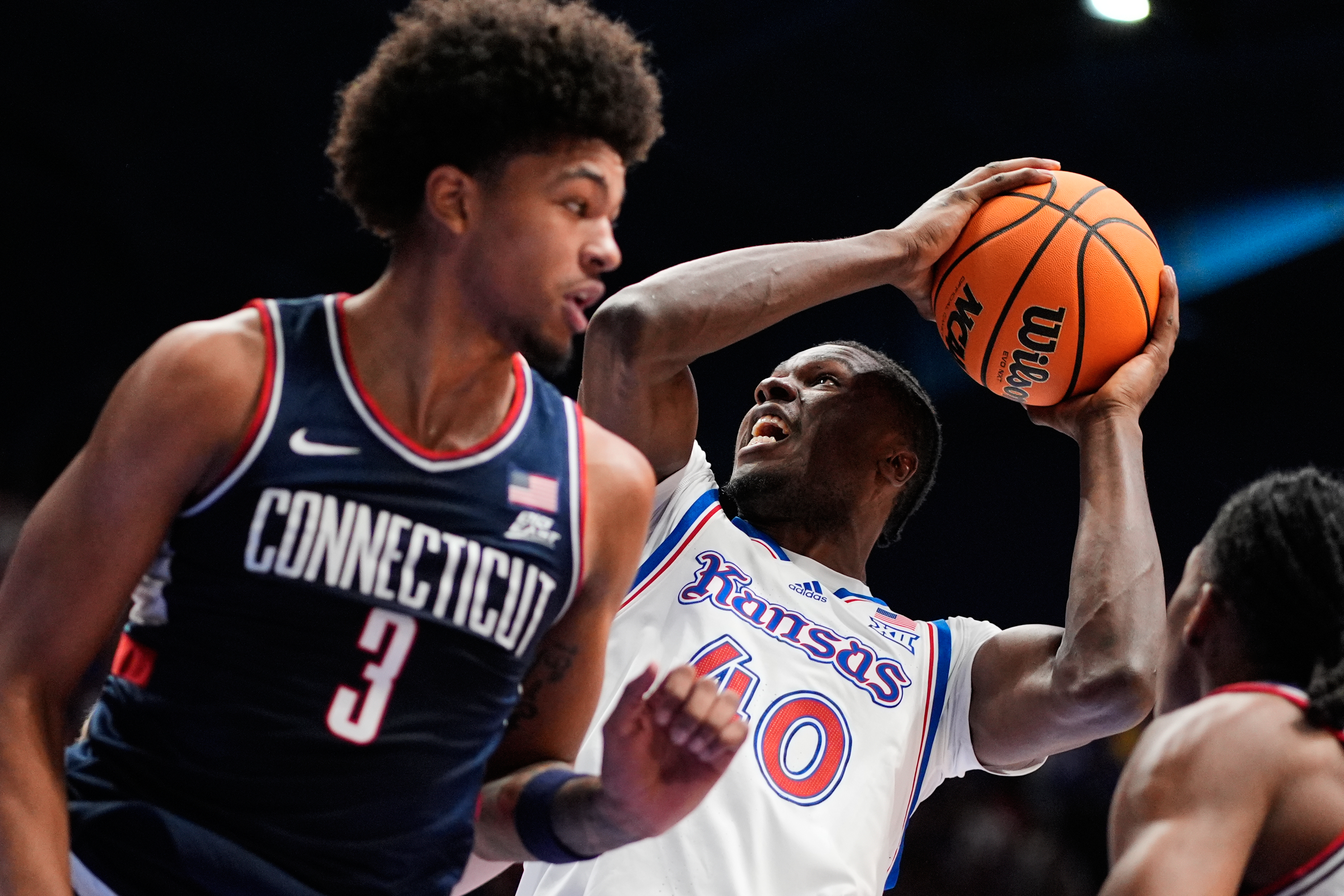 Kansas forward Flory Bidunga (40) shoots over UConn forward Jaylin Stewart (3) during the first half of an NCAA college basketball game Tuesday, Dec. 2, 2025, in Lawrence, Kan. 