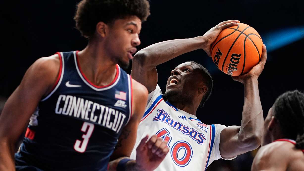 Kansas forward Flory Bidunga (40) shoots over UConn forward Jaylin Stewart (3) during the first half of an NCAA college basketball game Tuesday, Dec. 2, 2025, in Lawrence, Kan.