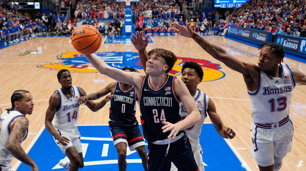 UConn guard Braylon Mullins (24) puts up a shot during the second half of an NCAA college basketball game against Kansas, Tuesday, Dec. 2, 2025, in Lawrence, Kan.