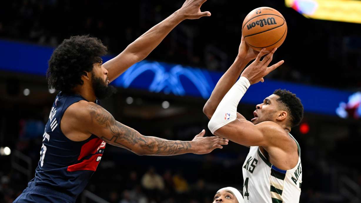 Milwaukee Bucks forward Giannis Antetokounmpo, right, prepares to score over Washington Wizards forward Marvin Bagley III, left, during the second half of an NBA basketball game Monday, Dec. 1, 2025, in Washington.
