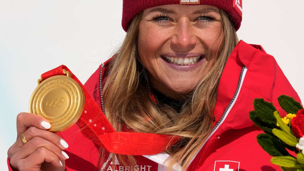 FILE - Switzerland's Corinne Suter poses during the medal ceremony for women's downhill at the 2022 Winter Olympics, Feb. 15, 2022, in the Yanqing district of Beijing.
