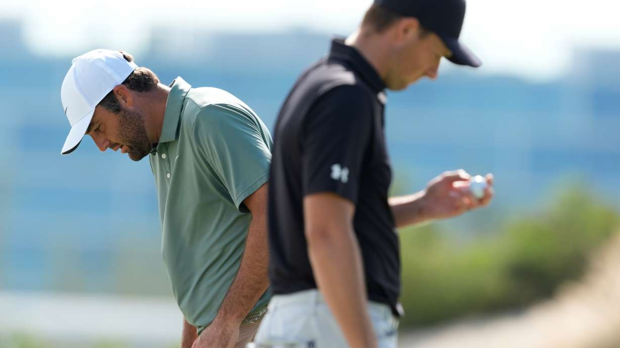 Scottie Scheffler, left, walks near Jordan Spieth, both of the United States, on the third green during the first round of the Hero World Challenge PGA Tour at the Albany Golf Club, in New Providence, Bahamas, Thursday, Dec. 4, 2025.